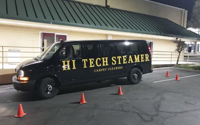A Shot Of A Black Branded Carpet Cleaning Company Vehicle Parked Outside A Service Site